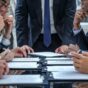 a-photo-of-several-people-in-suits-aroun_-_MUmnBsRVS3VcMqJcSGCQ_0bCB2bsbTkKzPYyBPcBQOQ